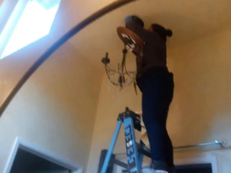 Electrician installing a chandelier in a Northlake residence